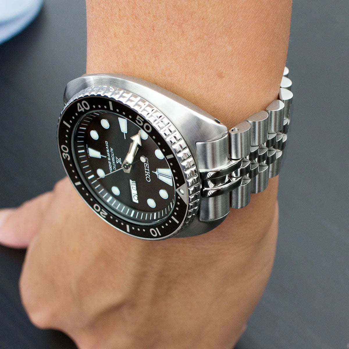 Stainless steel Super-J Louis bracelet on Seiko Turtle dive watch with black dial and rotating bezel worn on wrist