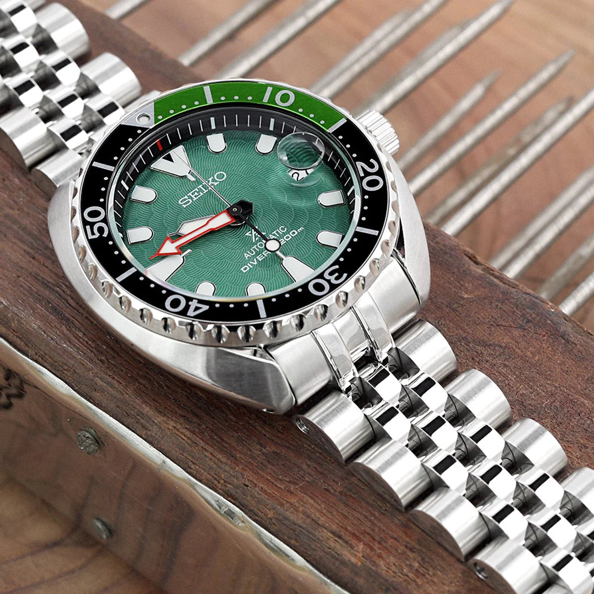 Seiko Mini Turtle dive watch with green dial and two-tone bracelet on wooden surface