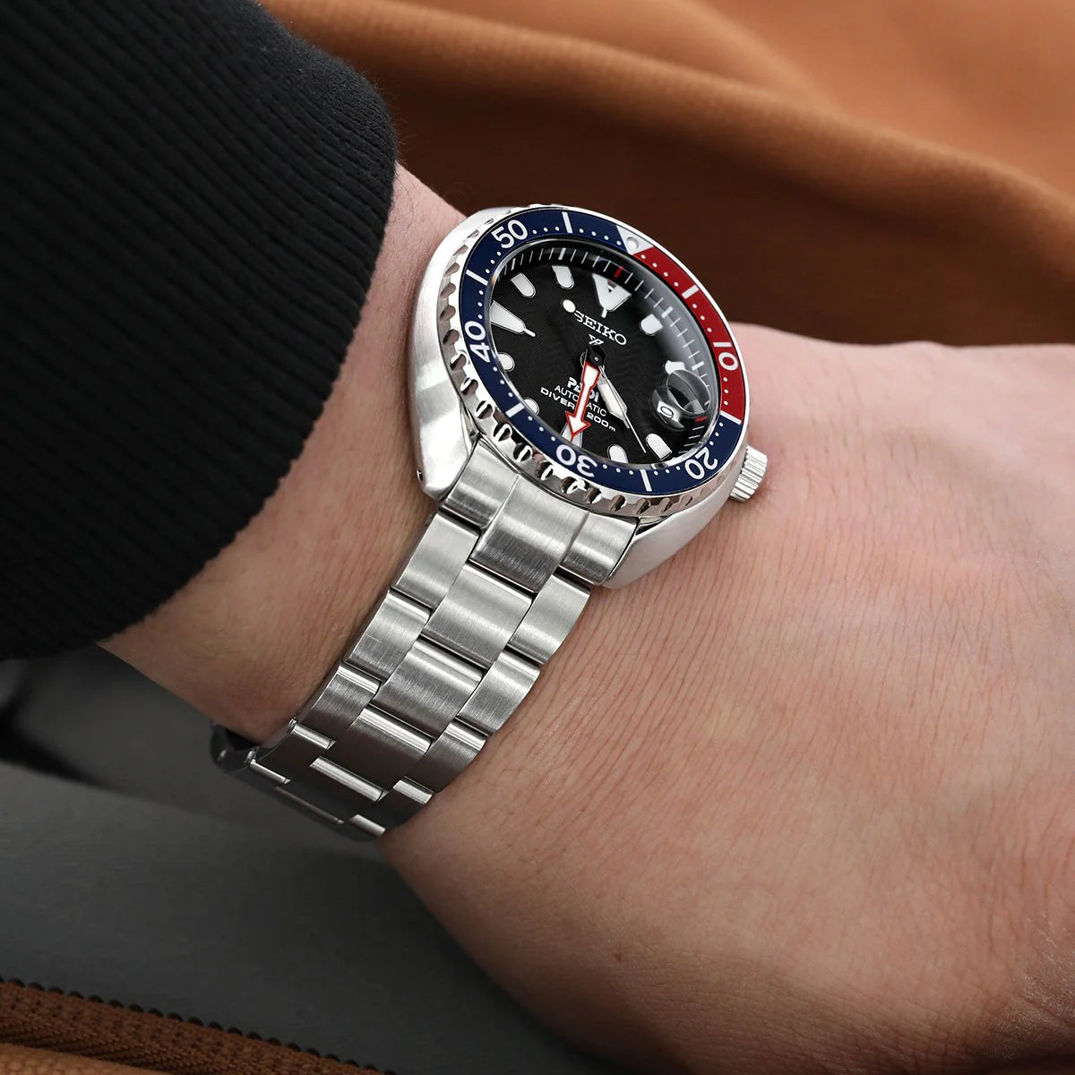 Seiko Mini Turtle SRPC35 dive watch with stainless steel Super-O Boyer bracelet on wrist, black dial with blue and red bezel