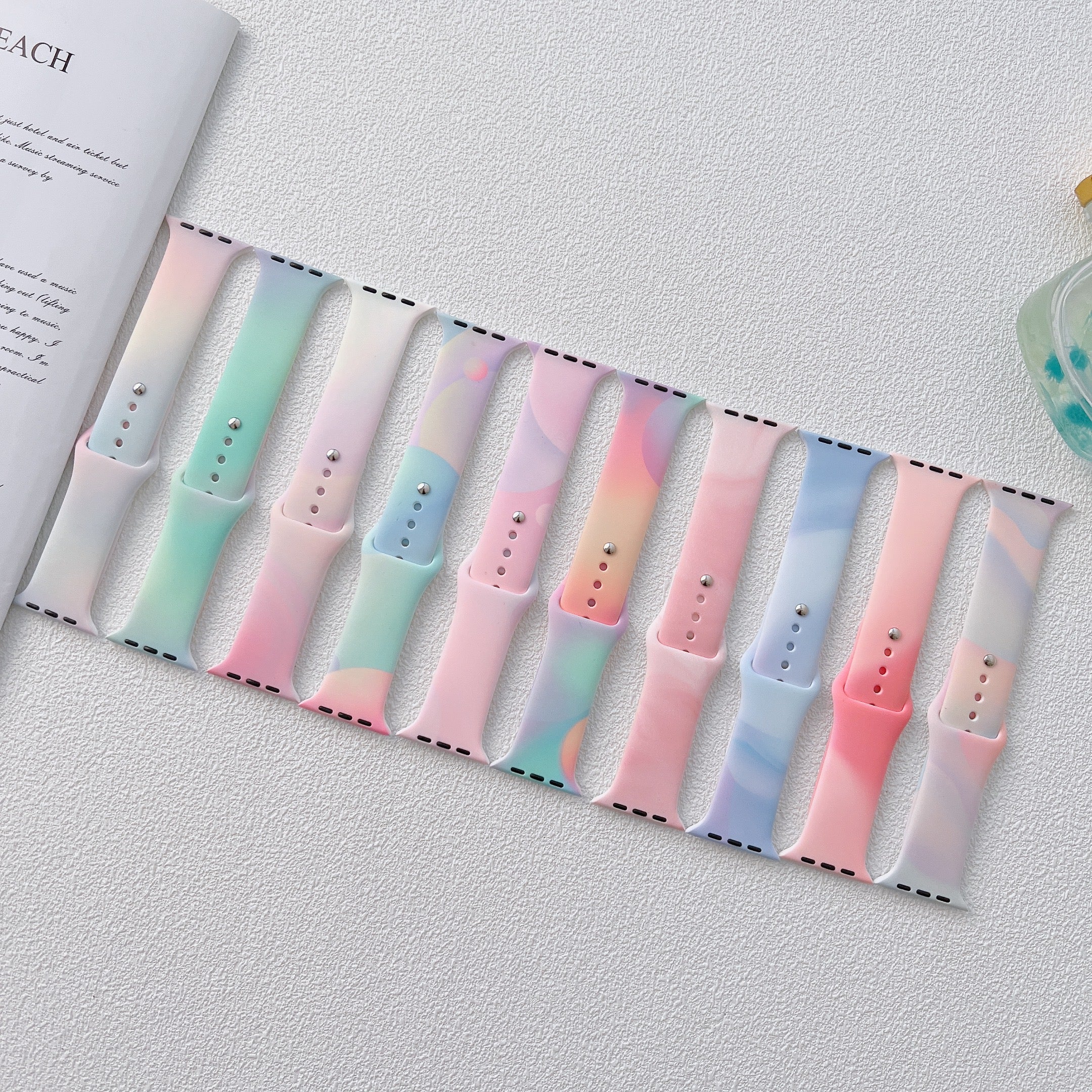 Collection of pastel gradient Apple Watch sport bands in pink, mint, blue and peach colors with adjustable sizing dots