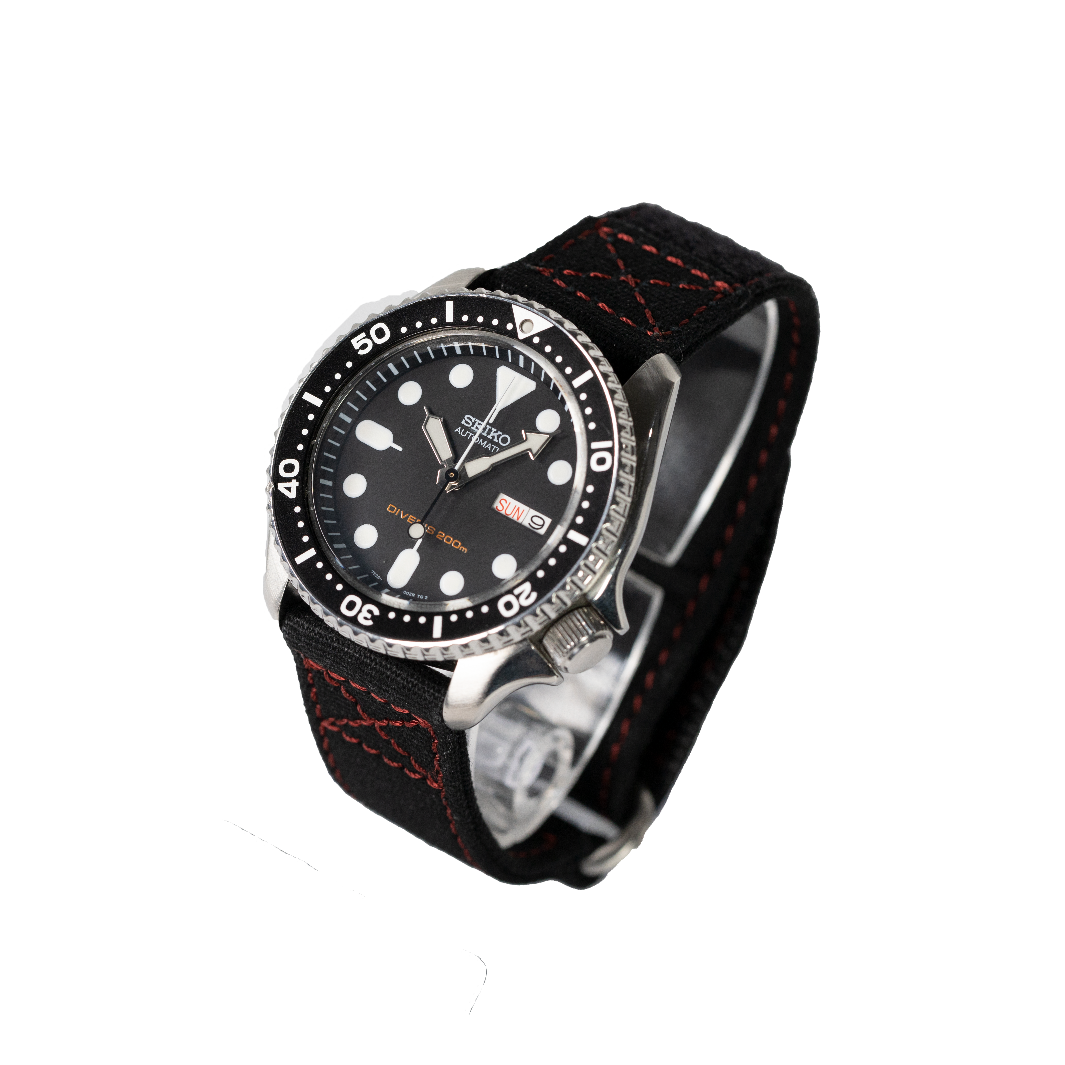 Black dive watch with stainless steel case, black dial, white markers, and black fabric strap with red stitching and quick release velcro