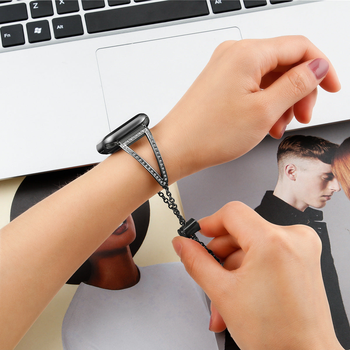 Apple Watch Nude Shimmer Bracelet in black with crystal embellishments worn on wrist next to keyboard