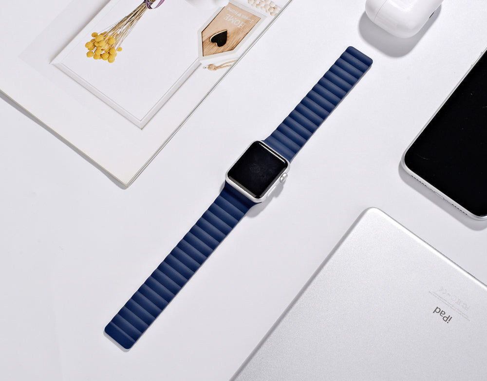 Apple Watch magnetic silicone loop band in navy blue with silver case on white background