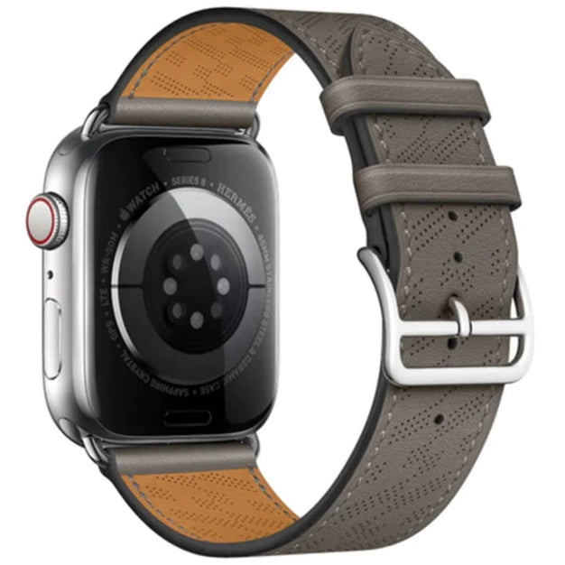 Silver Apple Watch with grey perforated leather single tour band featuring tan leather accents and silver buckle