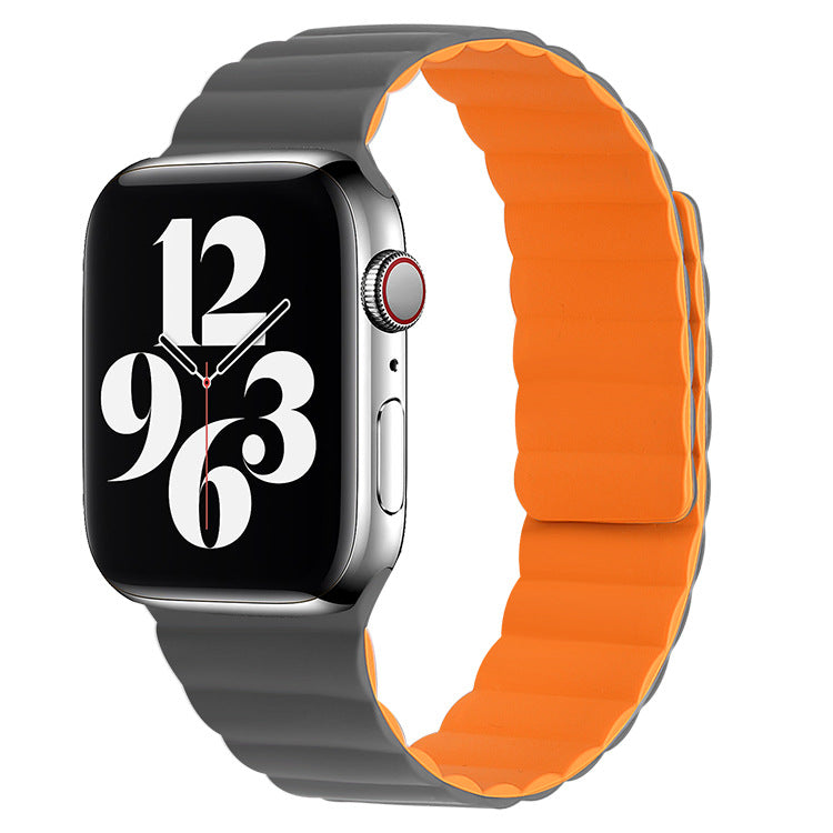 Silver stainless steel smartwatch with grey silicone band and reversible orange magnetic loop band included