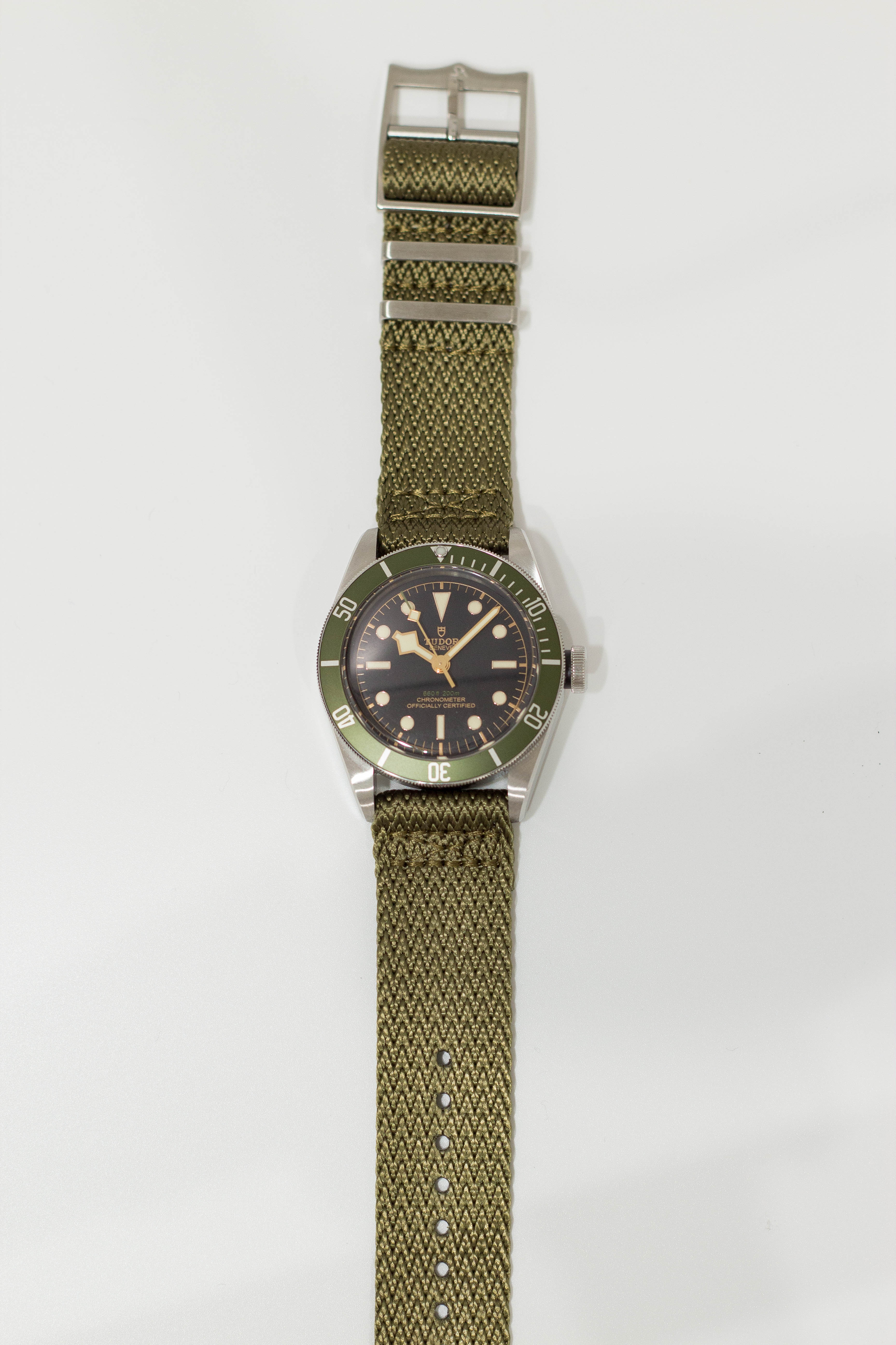 Vintage dive watch with black dial, green bezel, stainless steel case and army green fabric quick-release strap