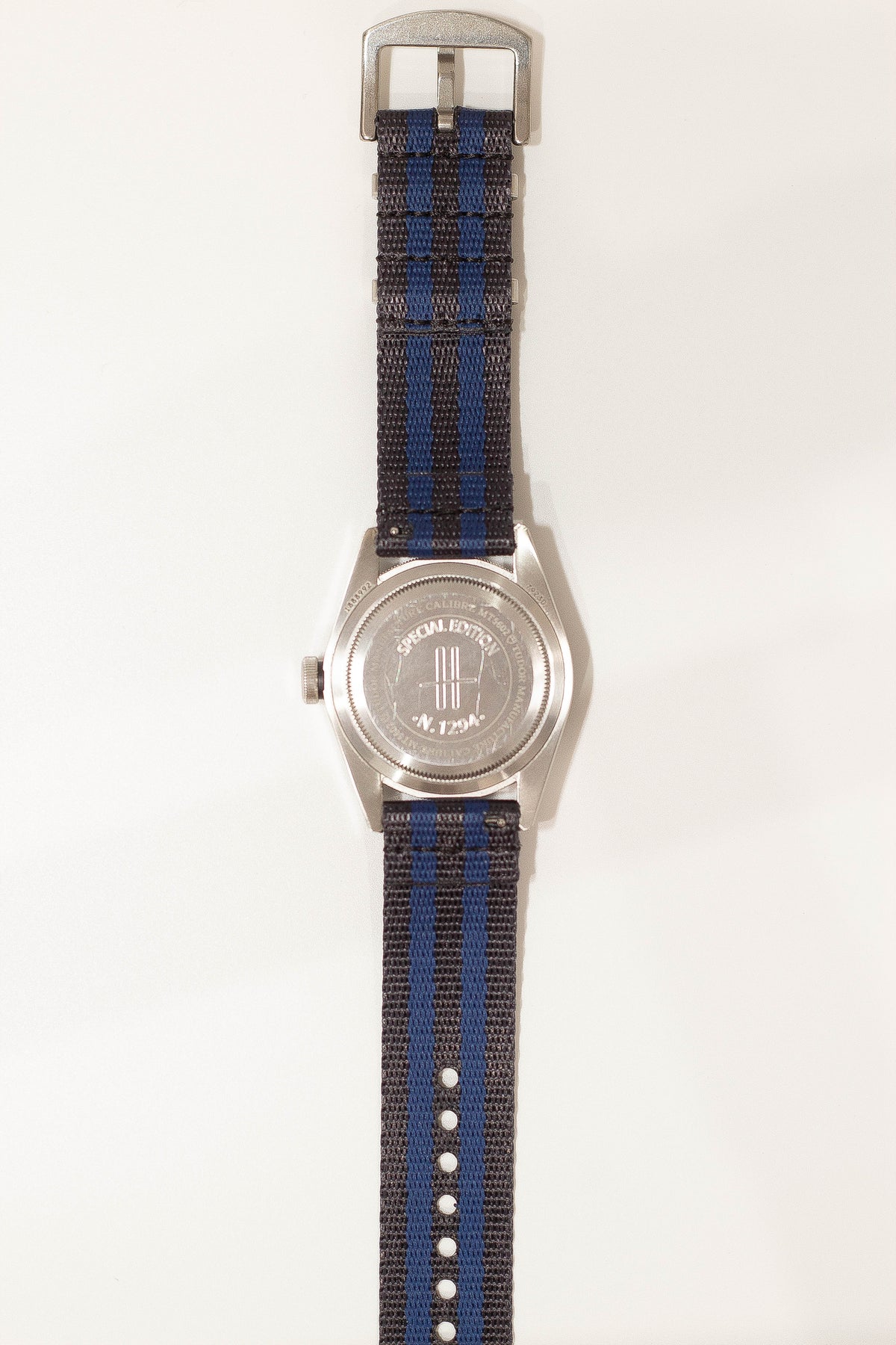 Silver-cased military watch with dark blue and navy woven fabric quick release strap and special forces emblem dial