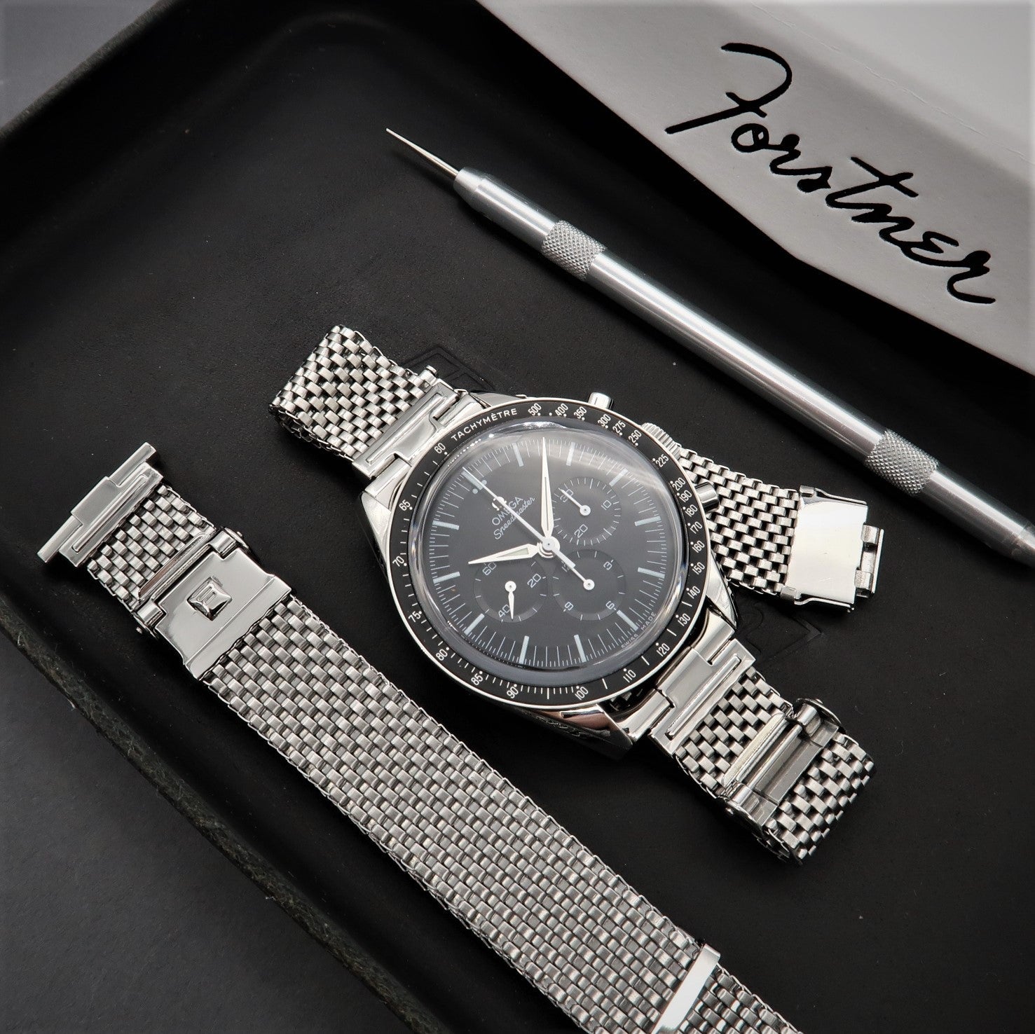 Stainless steel mesh watch bracelet with straight ends and integrated clasp clasp, featuring woven pattern design and professional watchmaking tools