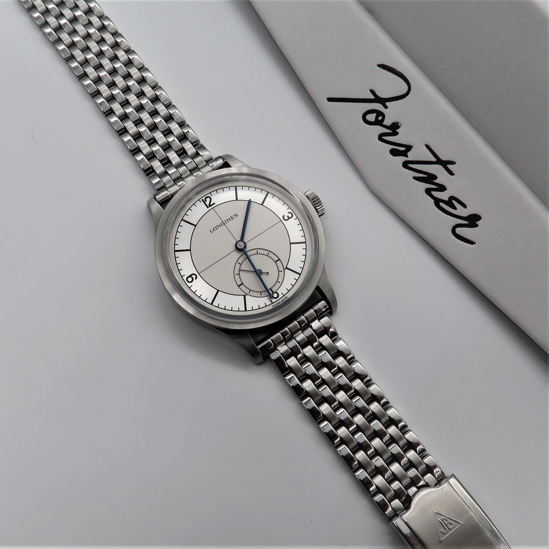Longines stainless steel watch with seven-row beads of rice bracelet and small seconds dial on white background
