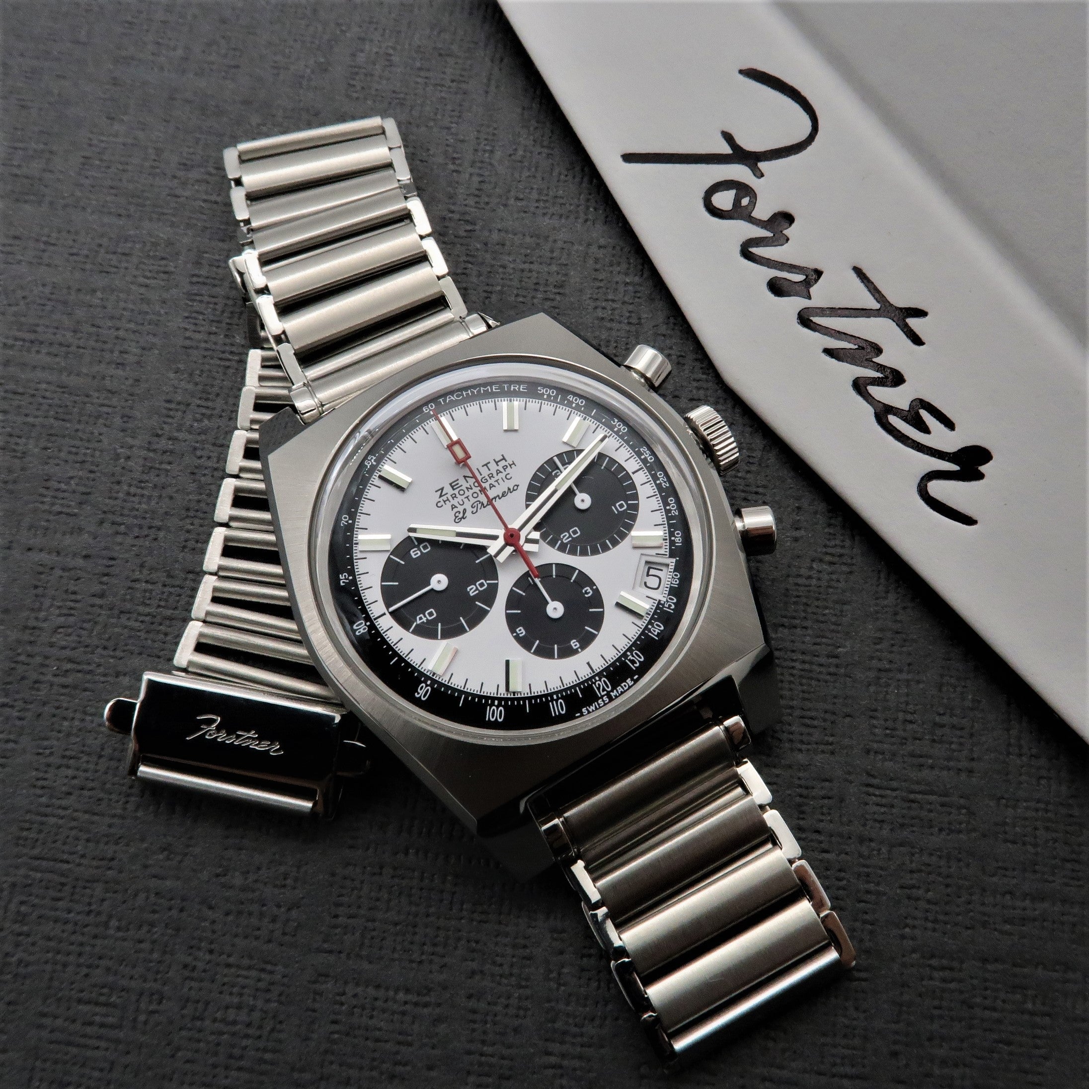 Zenith El Primero chronograph with stainless steel ladder-style bracelet on gray fabric with signed box