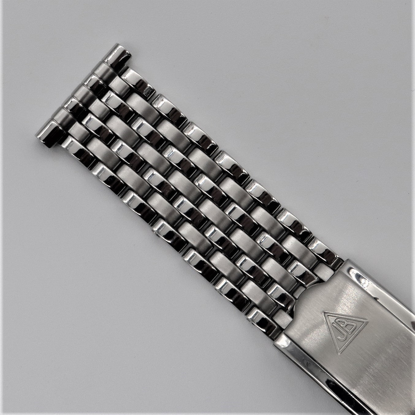 Stainless steel beaded watch bracelet with seven rows of rice-shaped links and brushed metal clasp