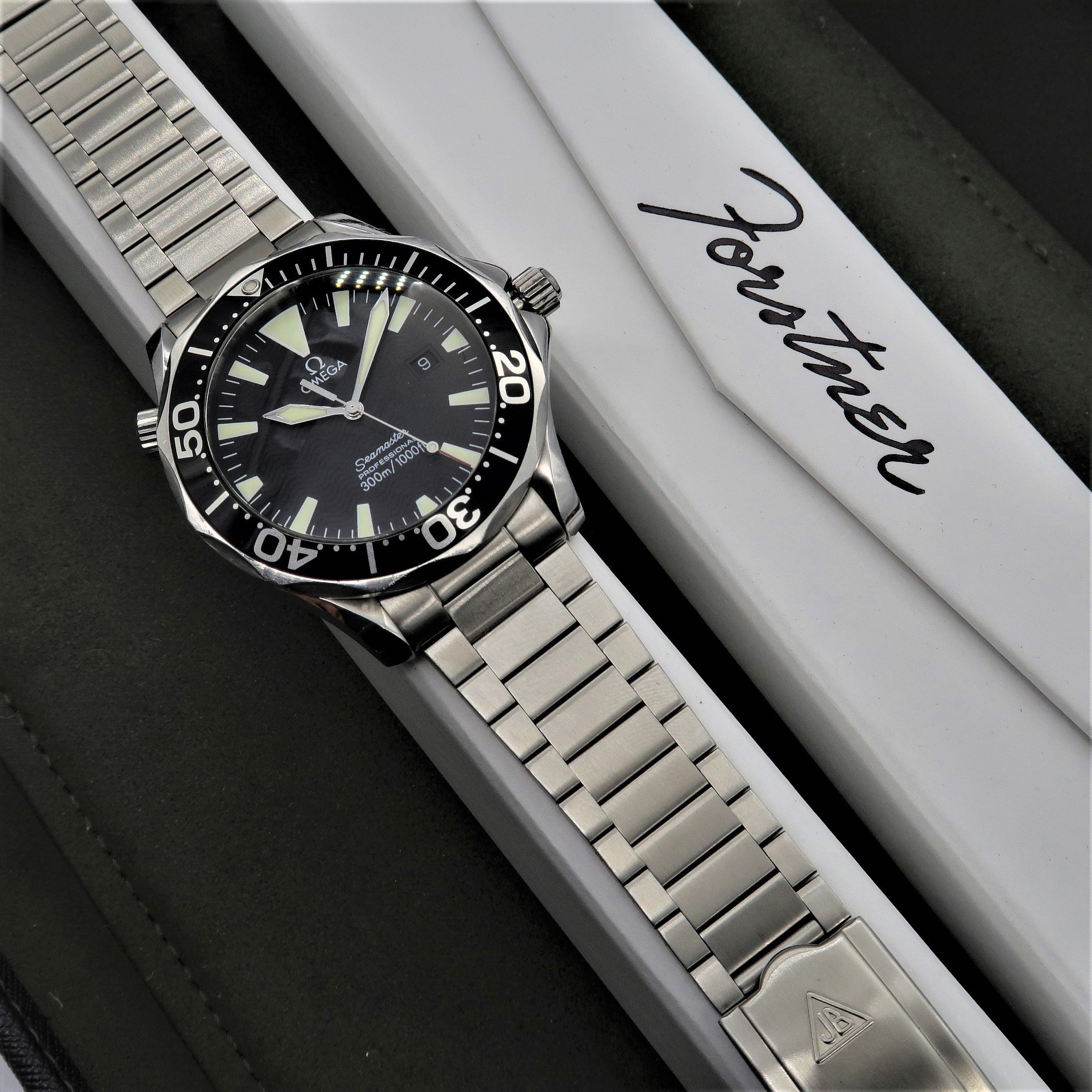 Omega Seamaster dive watch with stainless steel Forstner flat link bracelet on white presentation box
