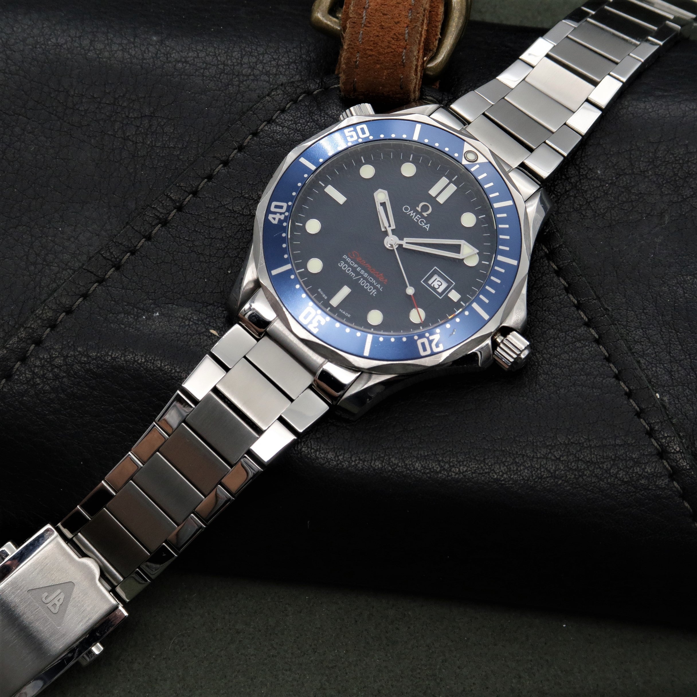 Omega Seamaster dive watch with blue bezel and steel bracelet on black leather strap