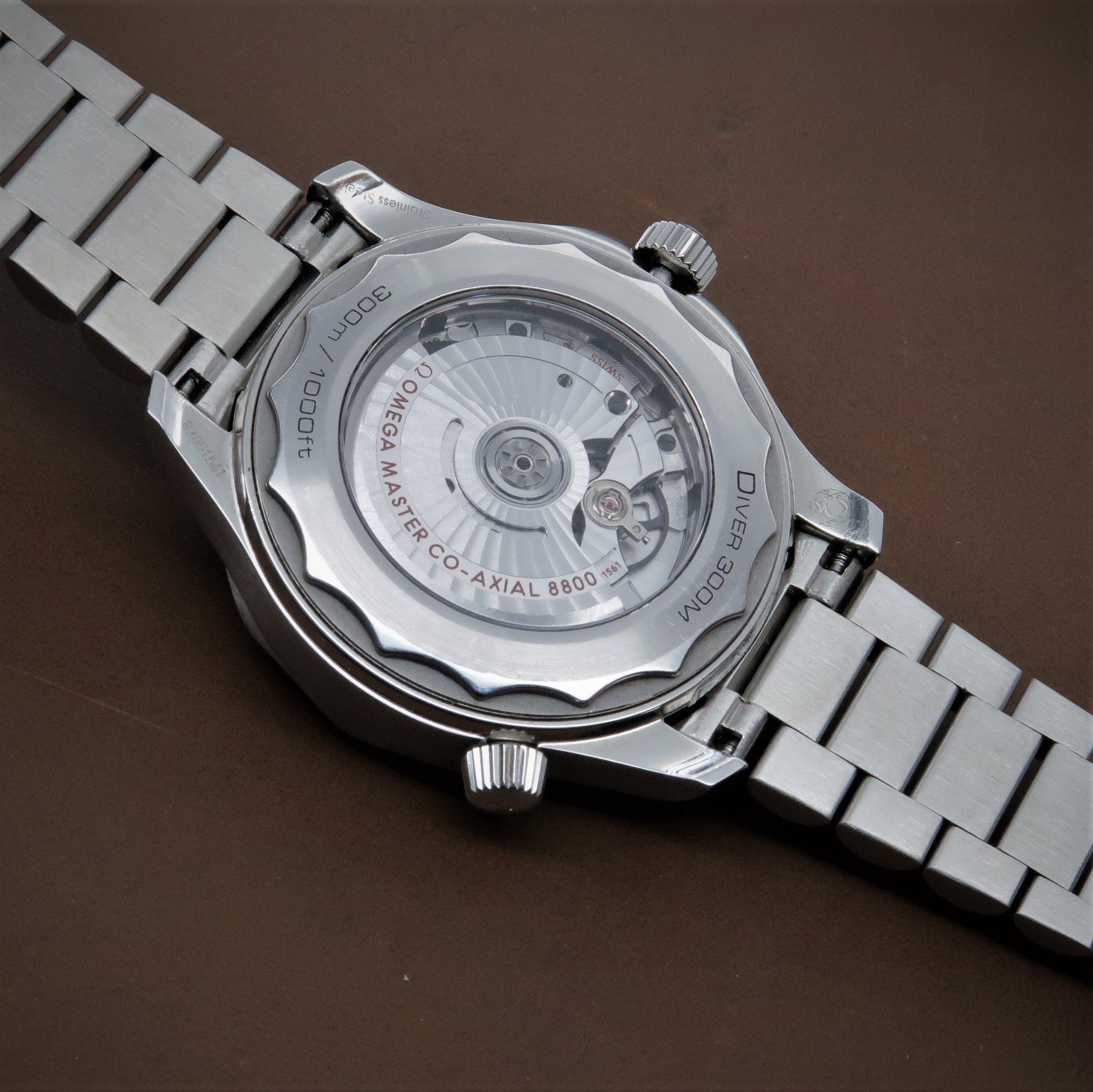 Omega Seamaster dive watch with stainless steel bracelet showing transparent caseback with co-axial 8800 movement