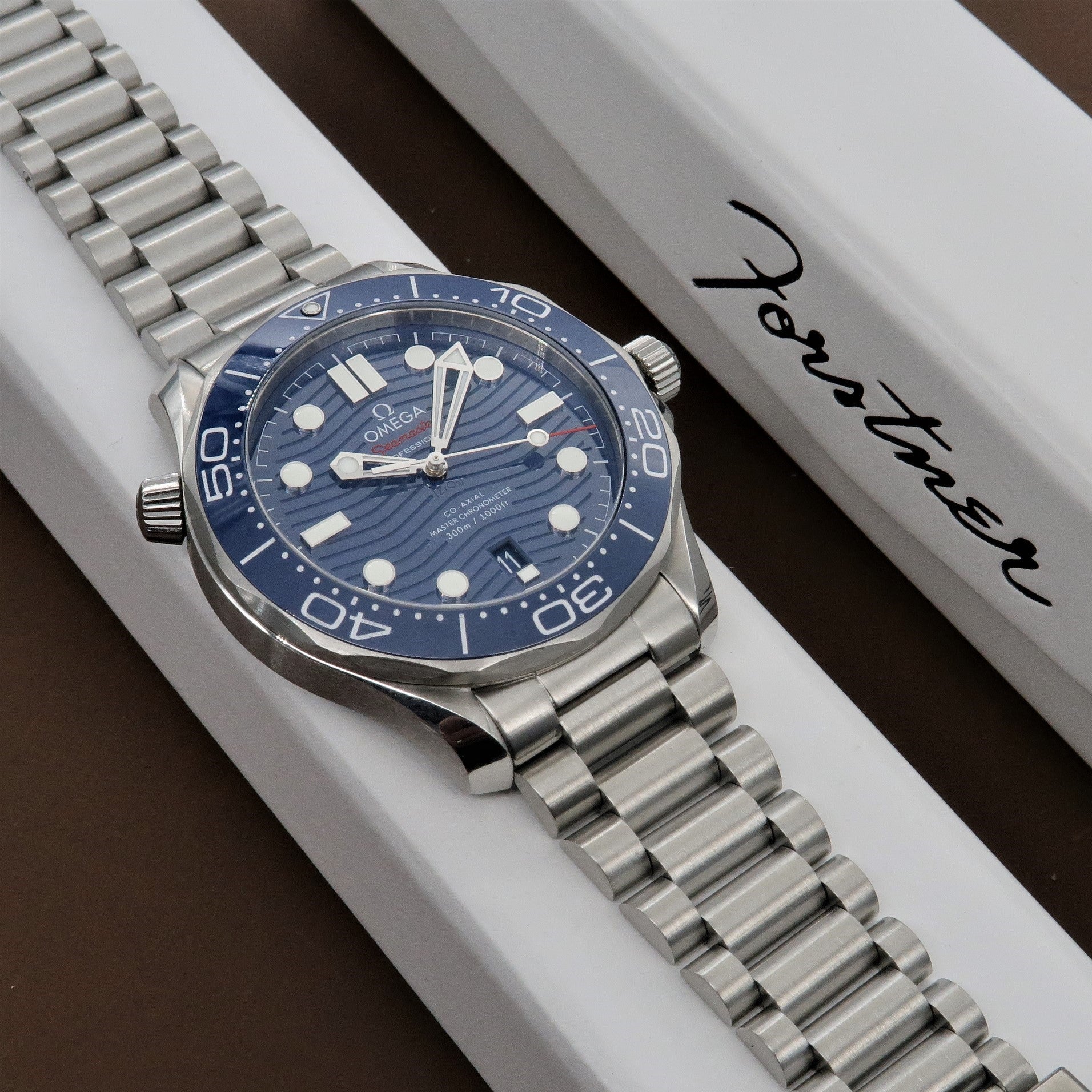 Omega Seamaster dive watch with blue dial and stainless steel bracelet on white display box