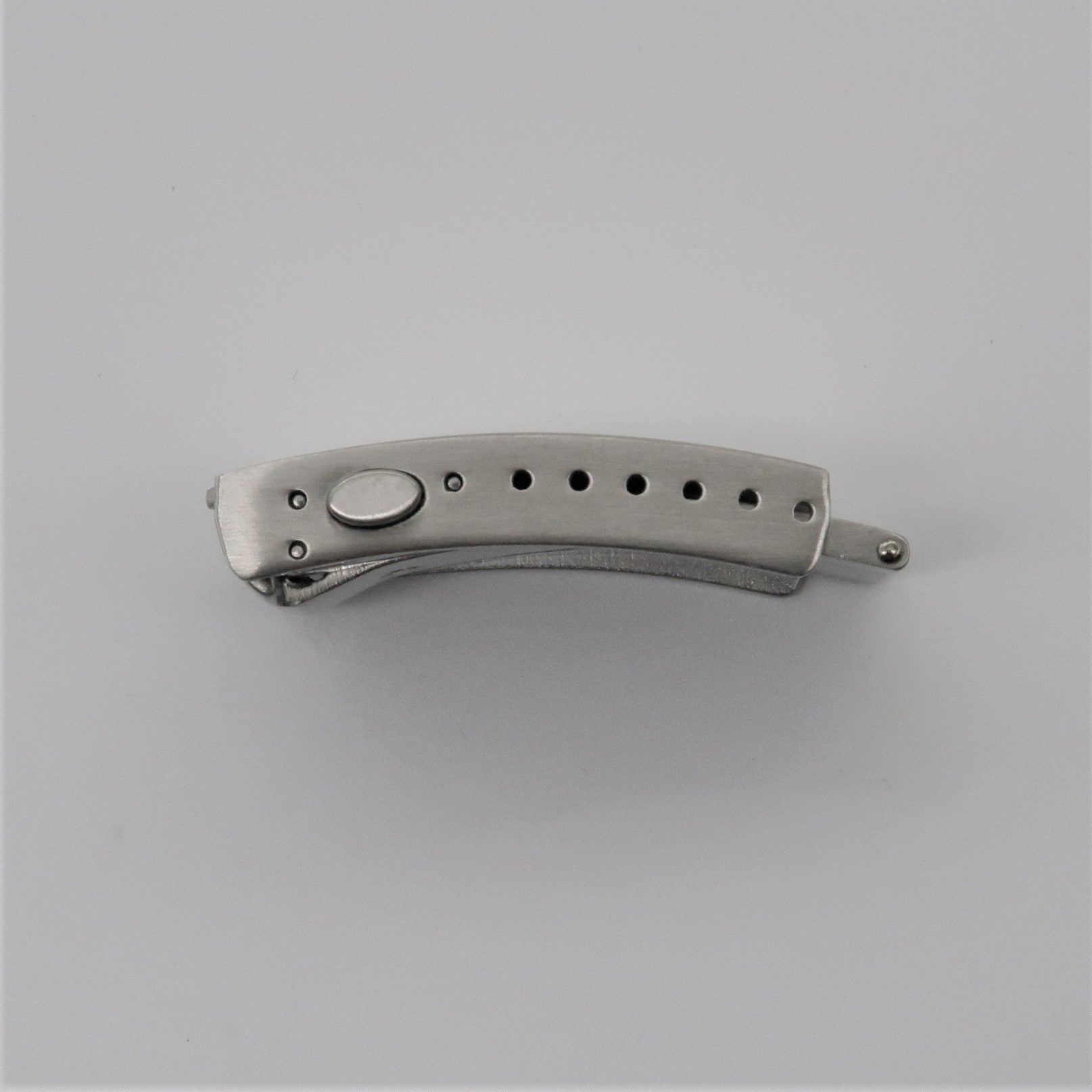 Stainless steel push-button folding knife with milled clasp and decorative hole pattern on handle