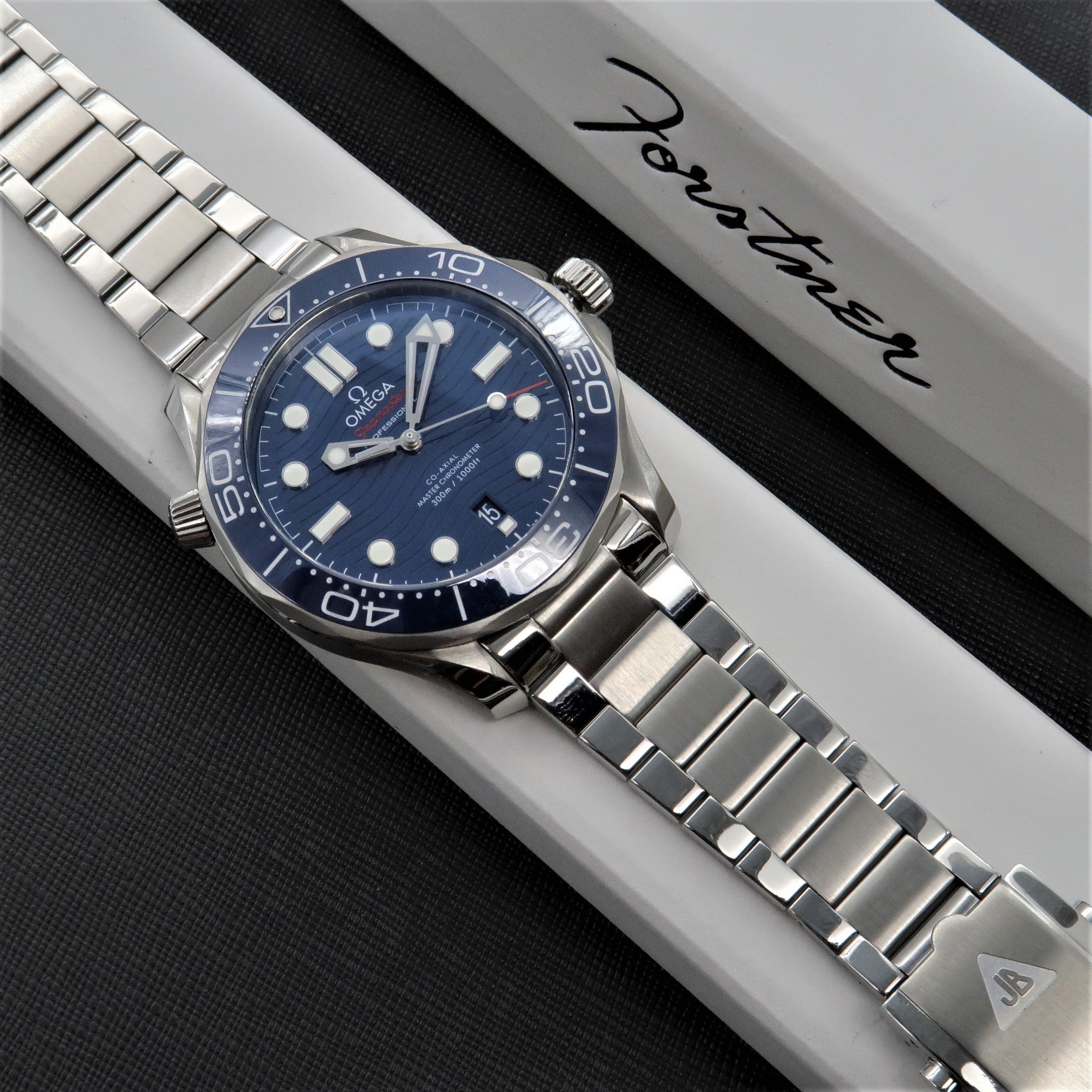 Omega Seamaster dive watch with blue dial and stainless steel bracelet on white display box