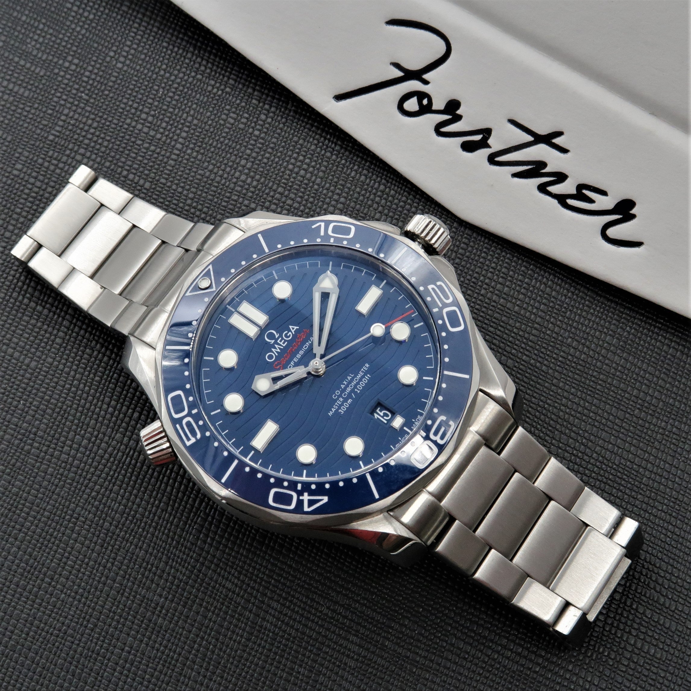 Omega Seamaster dive watch with blue dial and stainless steel bracelet on dark textured background
