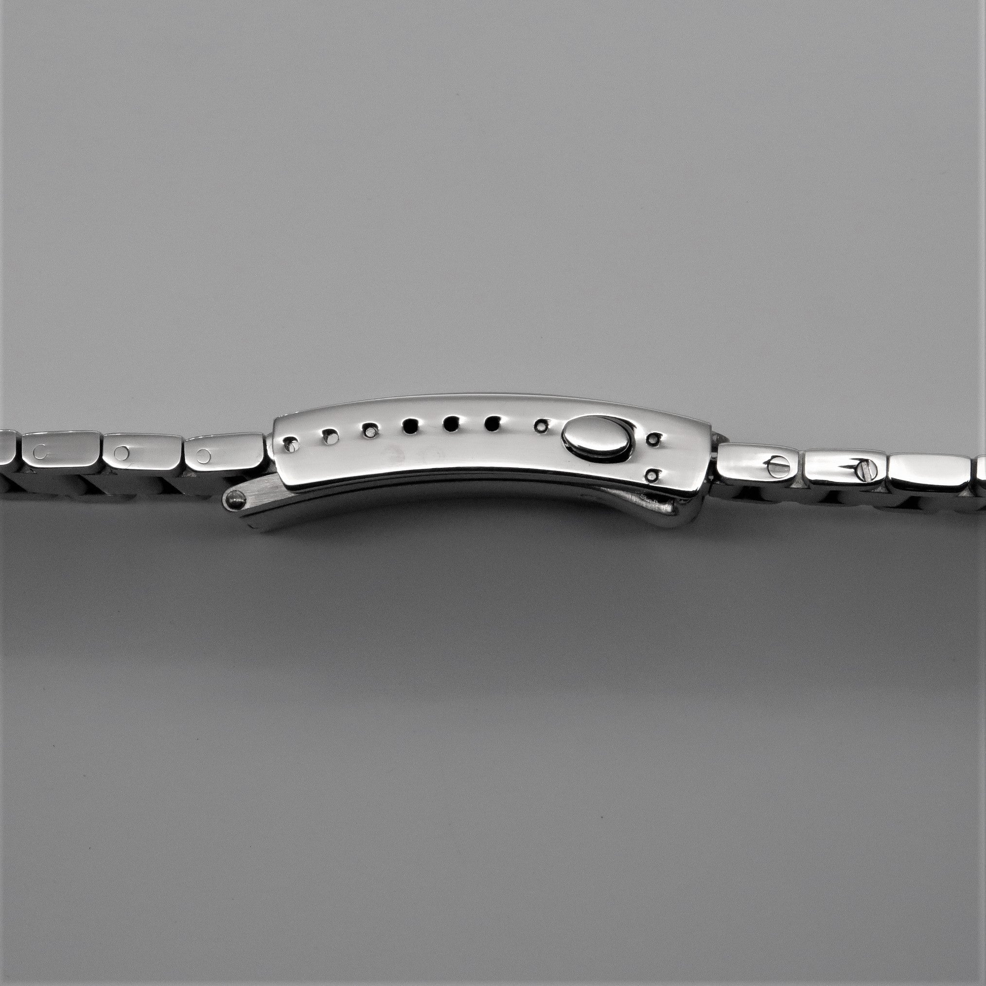 Polished stainless steel contemporary flat link bracelet with curved center link and round adjustment dial for Omega Seamaster watches