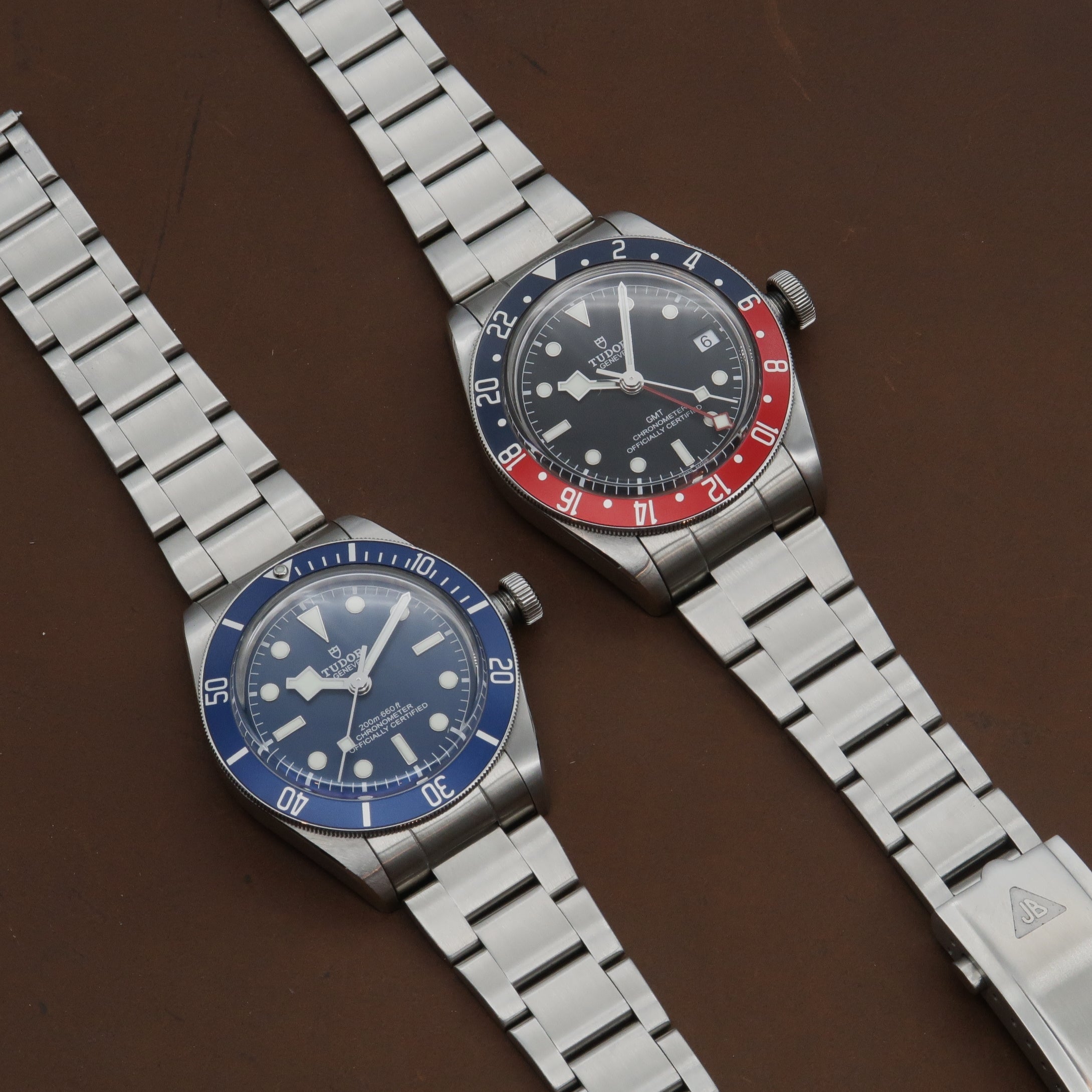 Tudor Black Bay dive watches with stainless steel bracelets, blue and red-blue bezels, black dials with luminous markers