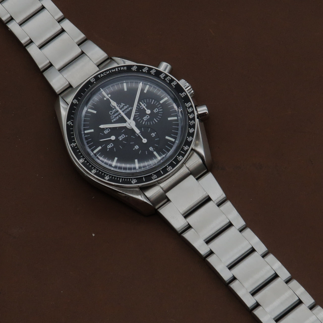 Omega Speedmaster chronograph watch with stainless steel bracelet and black dial featuring tachymeter bezel
