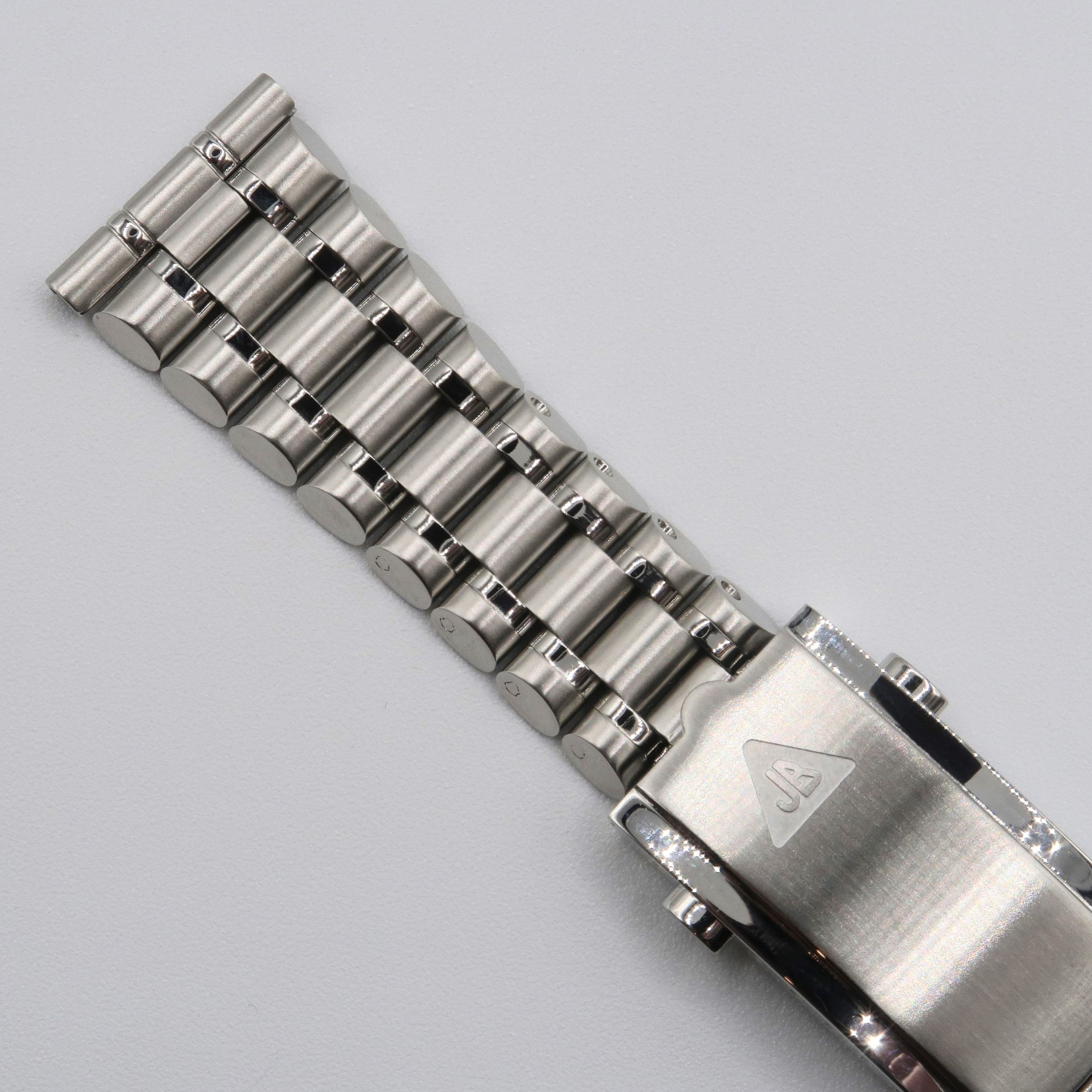 Stainless steel bullet bracelet with straight ends and polished cylindrical links on gray background