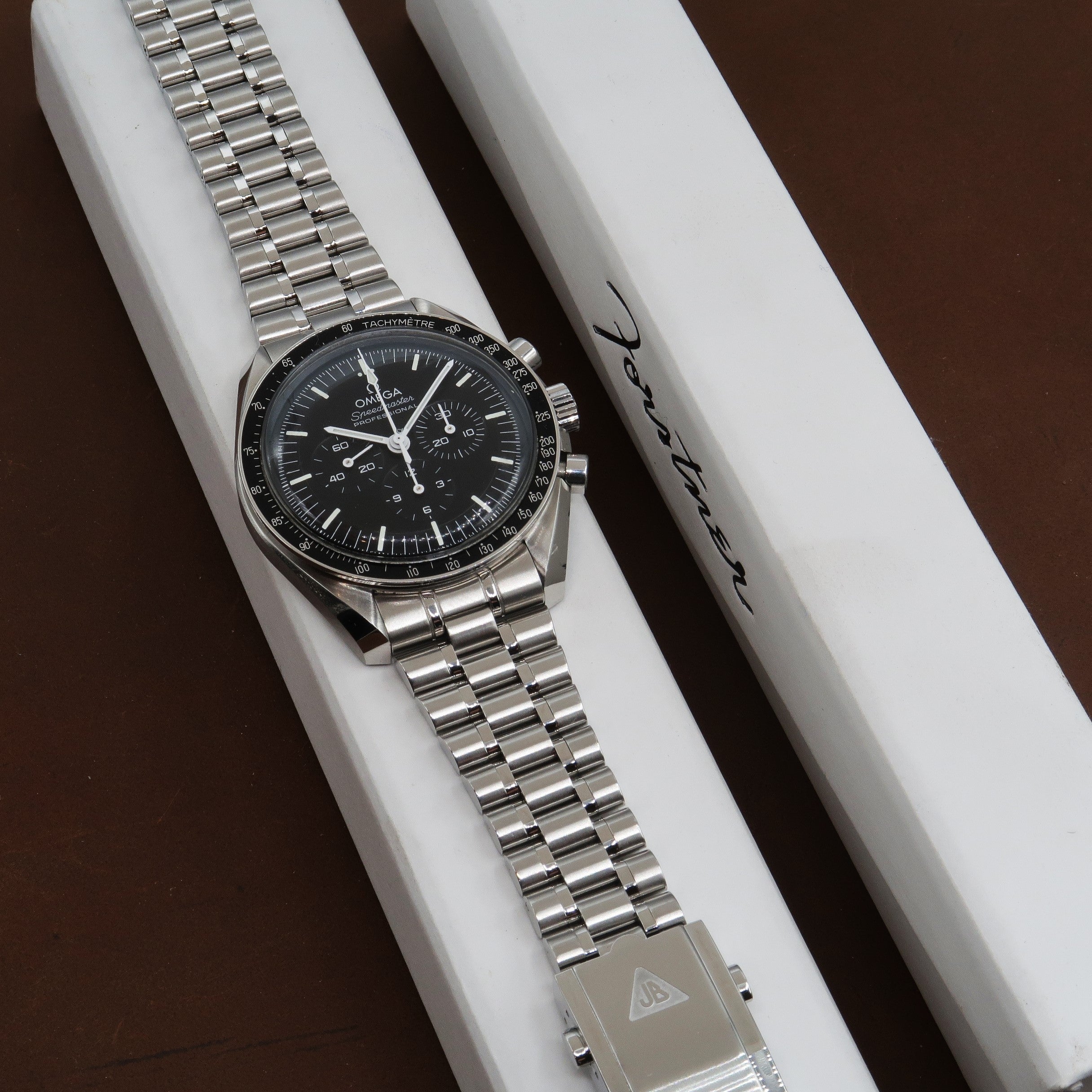 Omega Speedmaster Professional chronograph watch with steel bracelet and tachymetre bezel on white display box