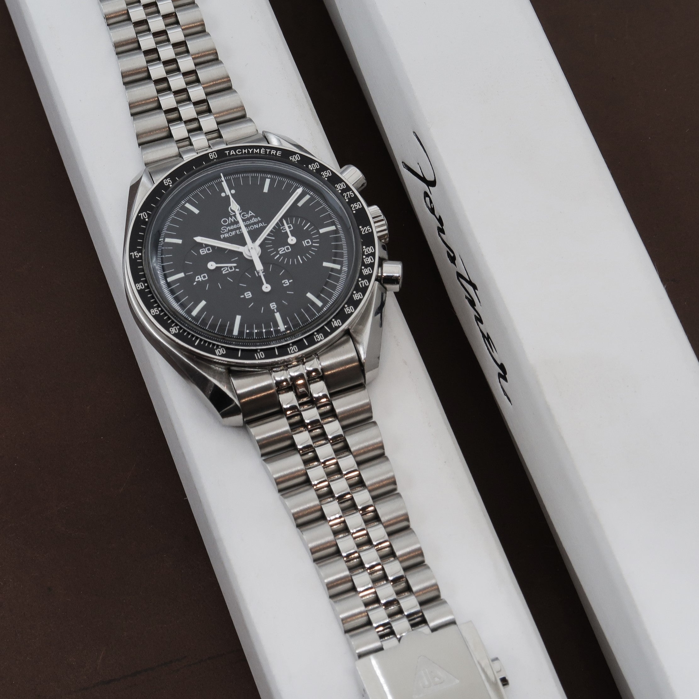 Omega Speedmaster Professional chronograph watch with stainless steel bracelet and black dial on white display box