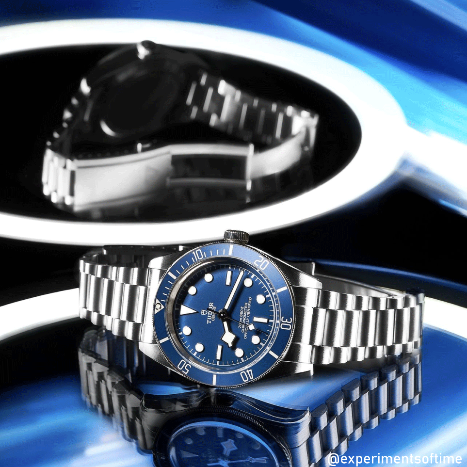 Stainless steel dive watch with blue dial and bezel, integrated metal bracelet, displayed on blue background with product packaging