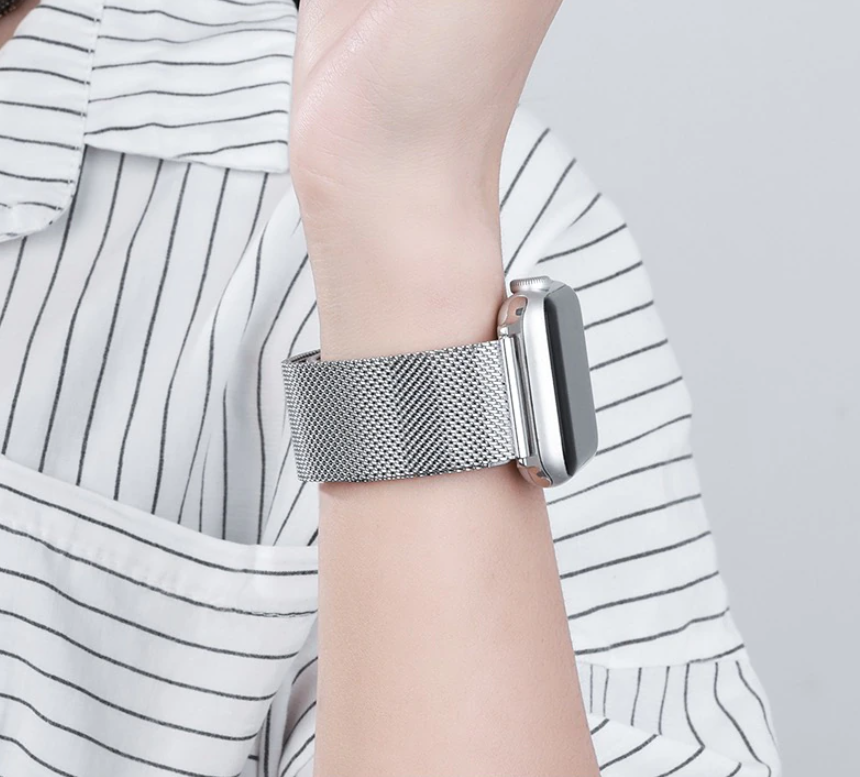 Silver Milanese mesh band with magnetic clasp for Apple Watch, worn on wrist with striped shirt