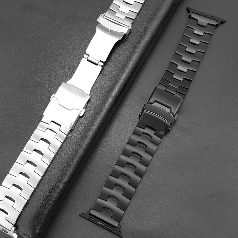 Stainless steel and black titanium Apple Watch bands with metal link bracelets displayed on gray leather background