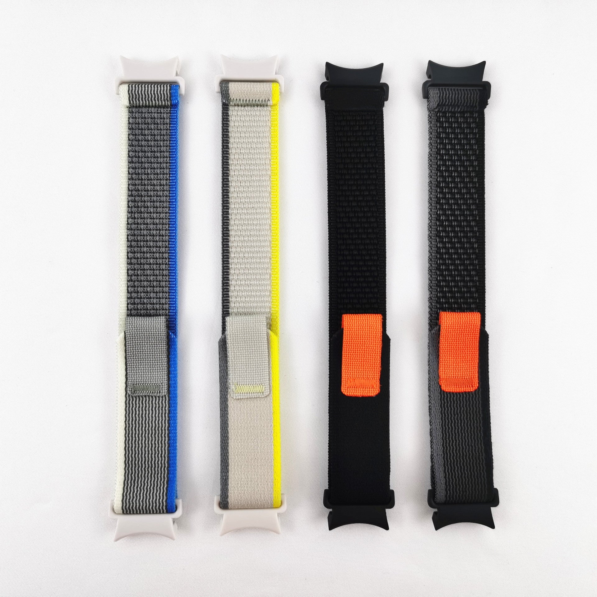 Four colorful Trail Loop smartwatch bands displayed vertically, featuring blue, yellow, black and orange striped nylon designs with adjustable fasteners
