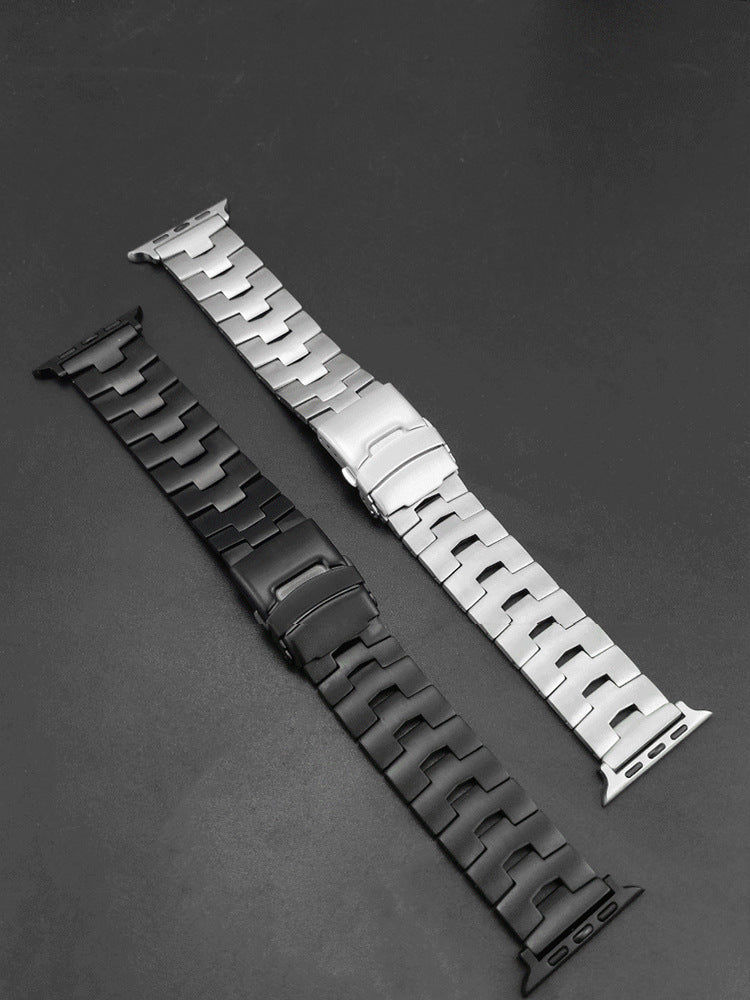 Silver and black stainless steel Apple Watch bands with metal link bracelets and connector adapters on gray background