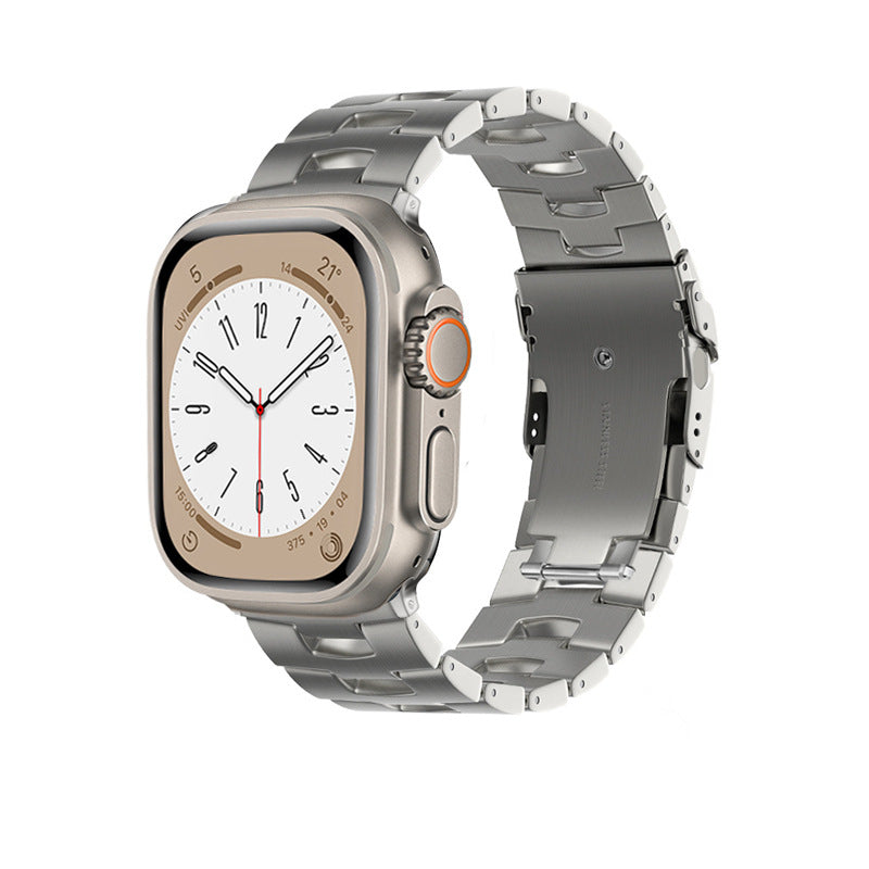 Titanium smartwatch with rectangular dial, white face, orange digital crown button, and matching titanium link bracelet strap