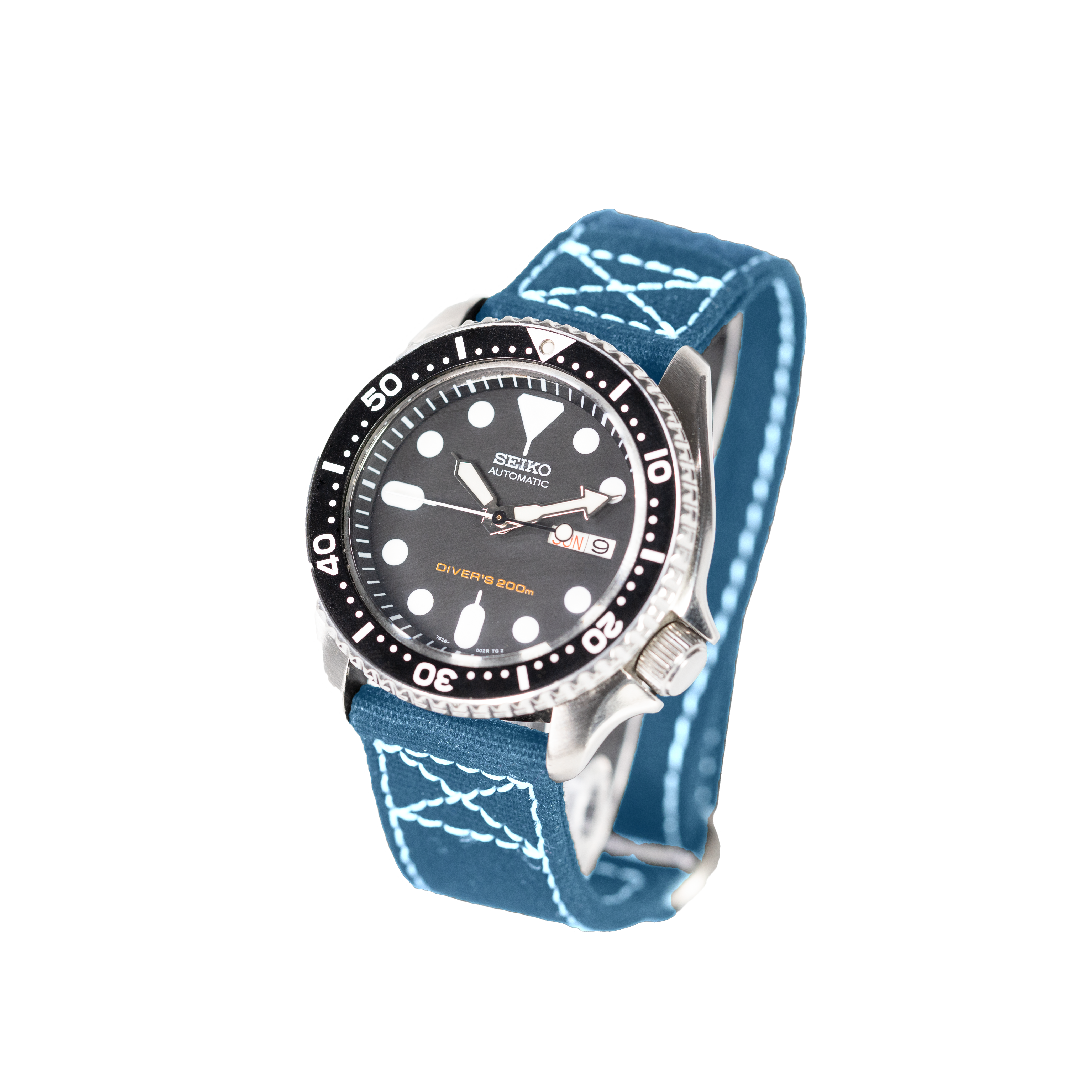 Seiko automatic dive watch with black dial, stainless steel case, and petrol blue fabric strap with white contrast stitching