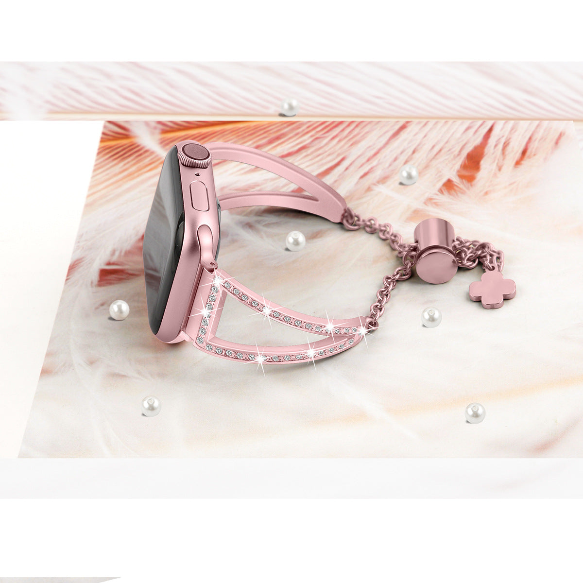 Rose pink crystal-studded Apple Watch bracelet with charm attachments on feathered background