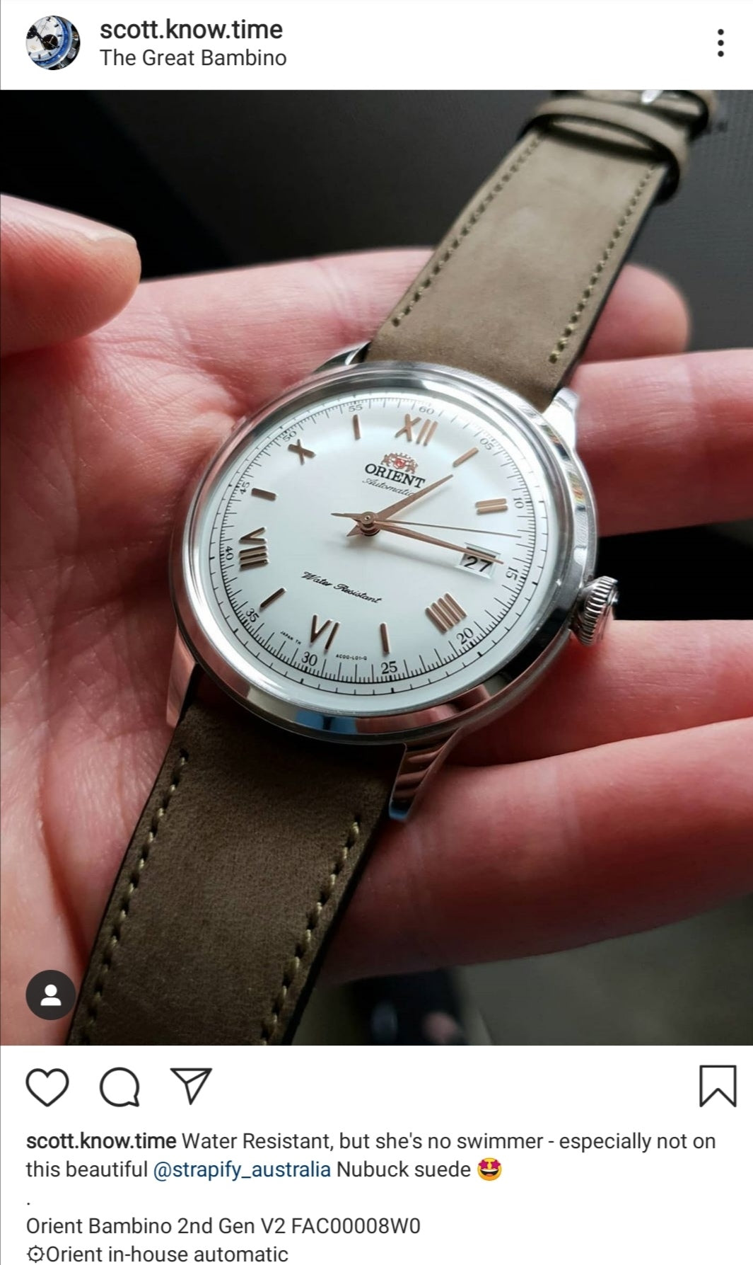 Orient Bambino automatic watch with white dial, Roman numerals, and olive green nubuck leather strap held in hand