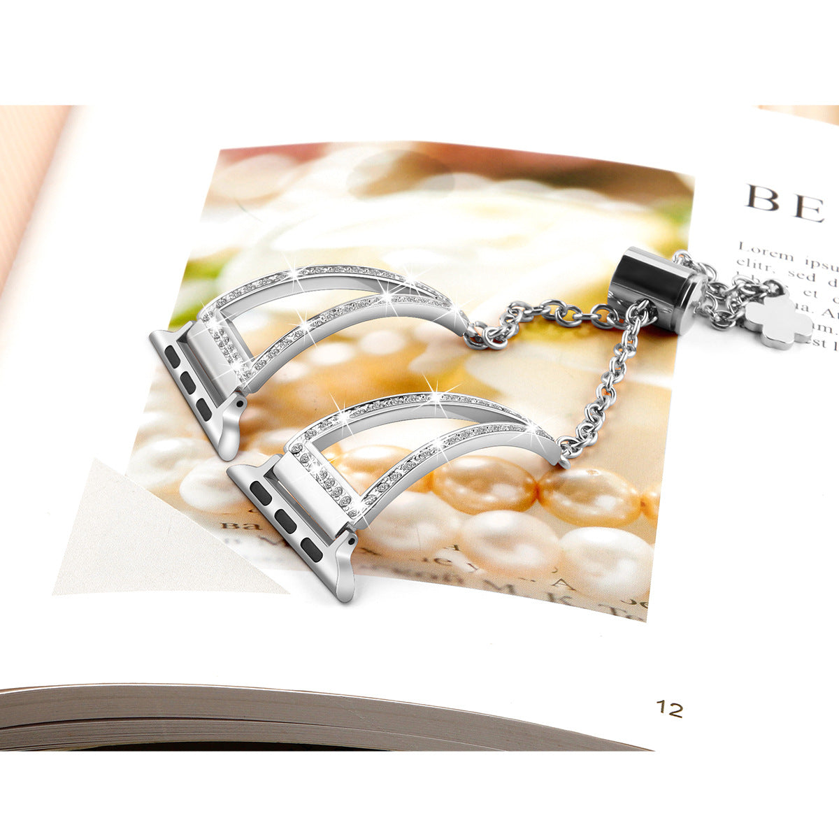 Silver diamond-studded Apple Watch band bracelet pair with chain connector on magazine page backdrop