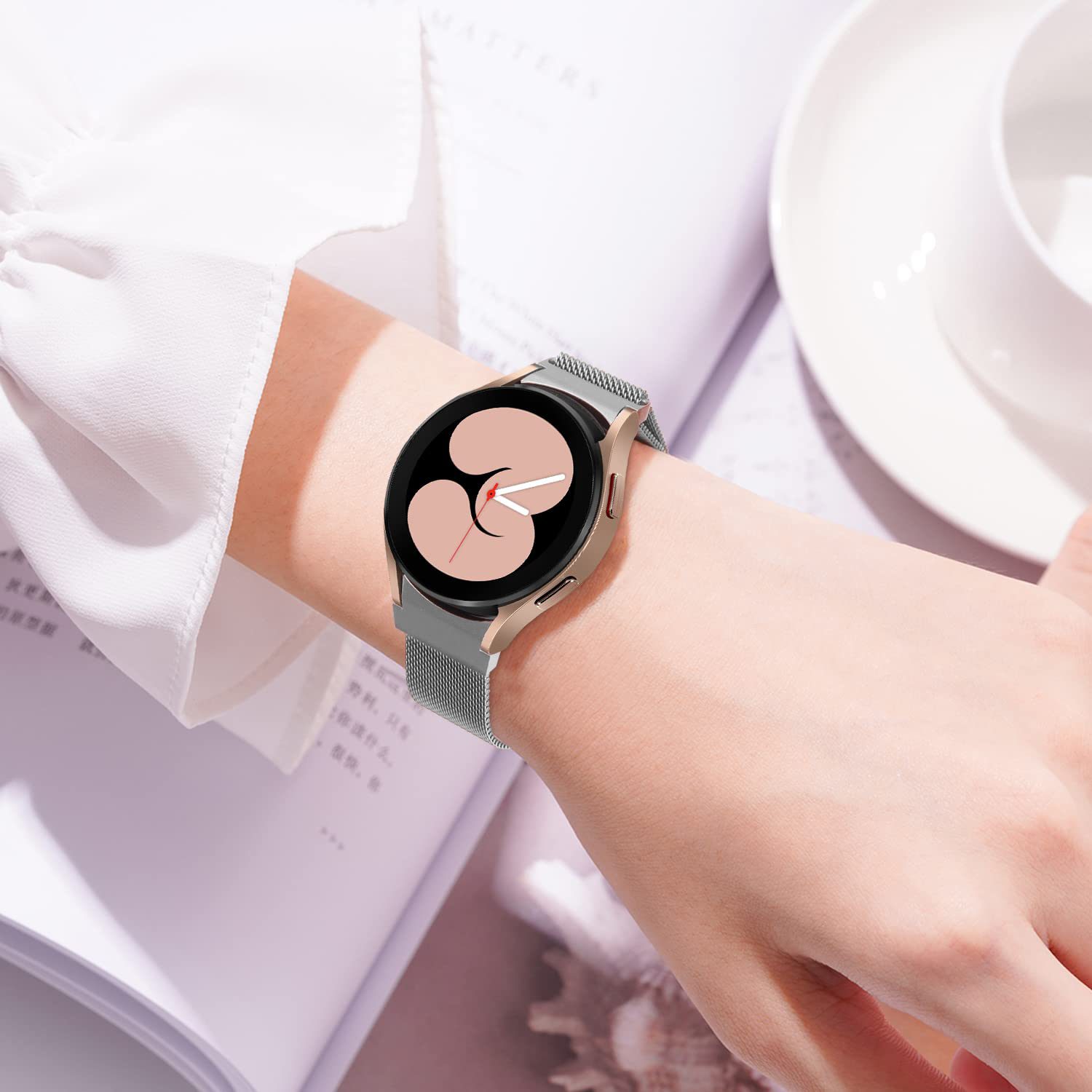Samsung Galaxy Watch 4-7 silver Milanese mesh band smartwatch worn on wrist with black dial face