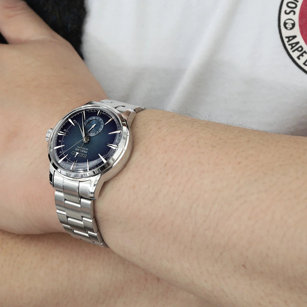 Strapcode Super-O Boyer bracelet on Seiko Cocktail SSA345 watch with dark blue dial, displayed on wrist with steel links