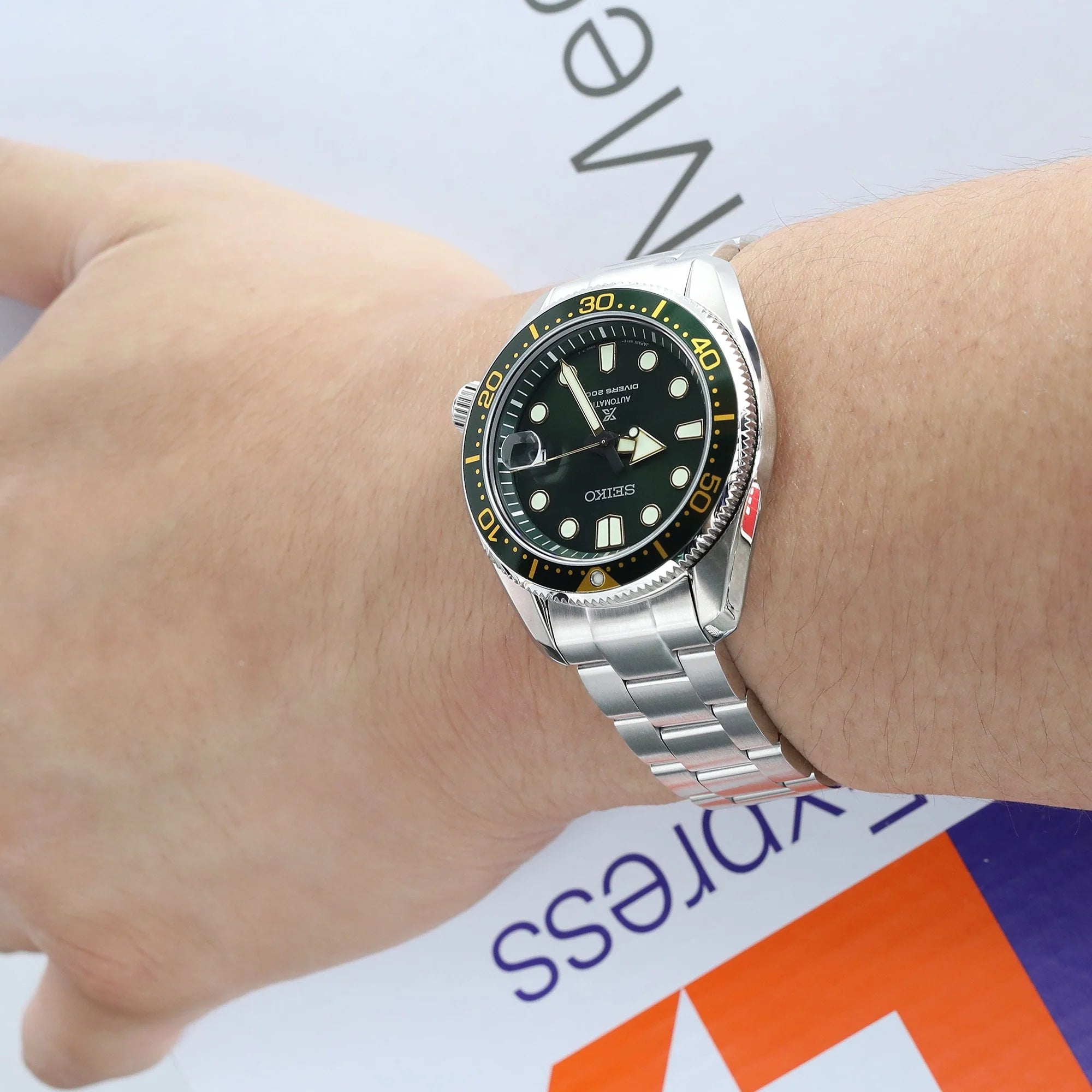 Strapcode Super-O Boyer bracelet on Seiko Baby MarineMaster MM200 dive watch with black dial and gold bezel on wrist