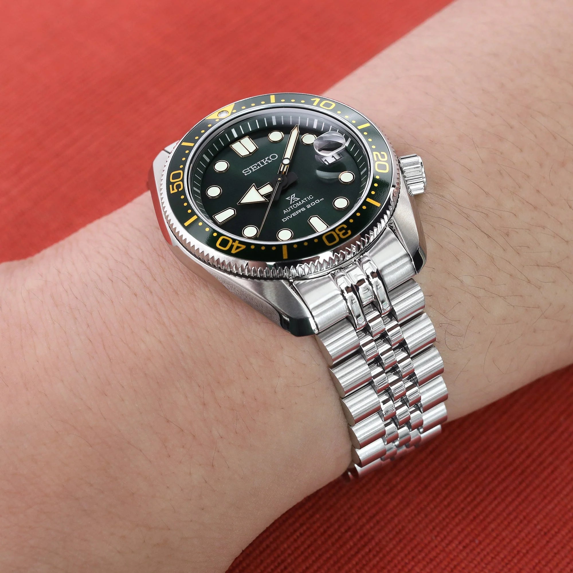 Seiko automatic diving watch with black dial and gold bezel on stainless steel Super-J jubilee bracelet