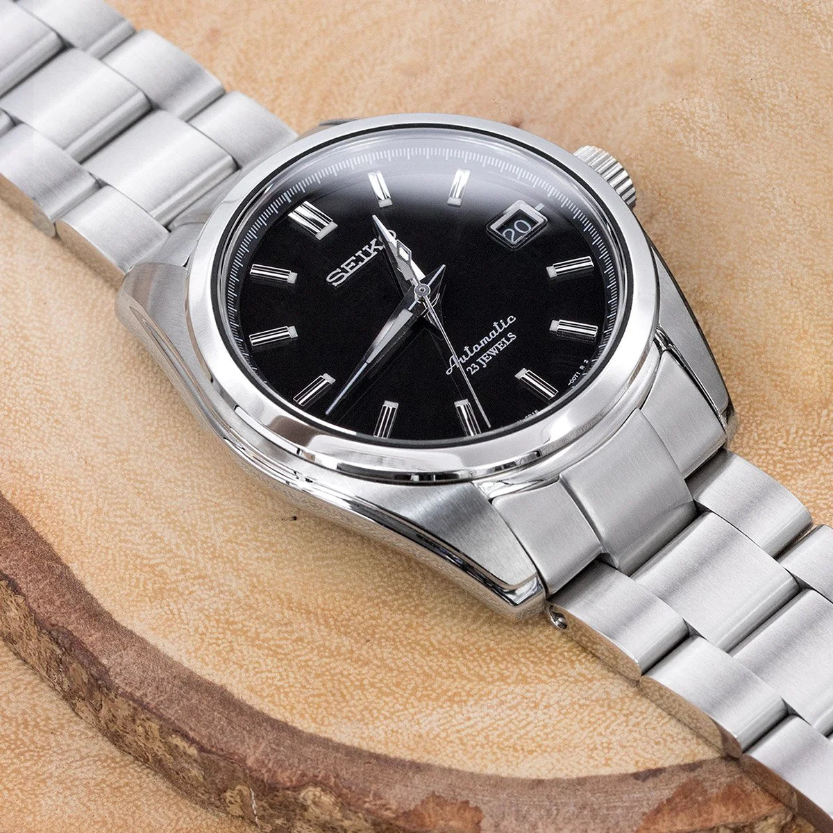Seiko SARB033 automatic watch with stainless steel Super-O Boyer bracelet on beige textured background