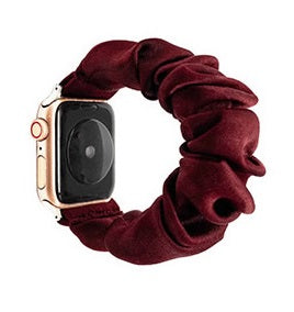 Burgundy velvet scrunchie loop with gold Apple Watch case attached, smartwatch accessory