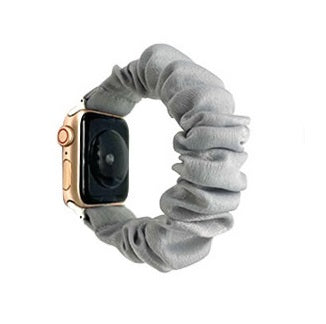 Gray fabric scrunchie Apple Watch band with gold aluminum case and digital display