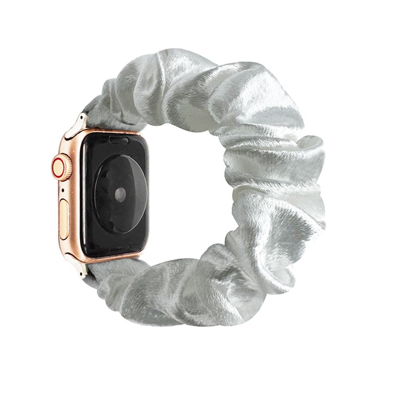 Rose gold smartwatch with silver metallic scrunchie fabric loop band on white background