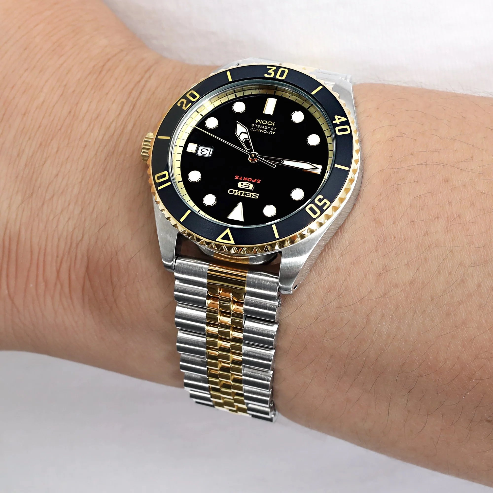 Two-tone steel and gold jubilee bracelet watch with black dial and rotating bezel on wrist