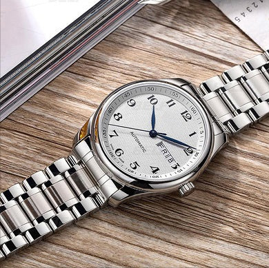 Silver stainless steel curved bracelet watch with white dial on wooden surface