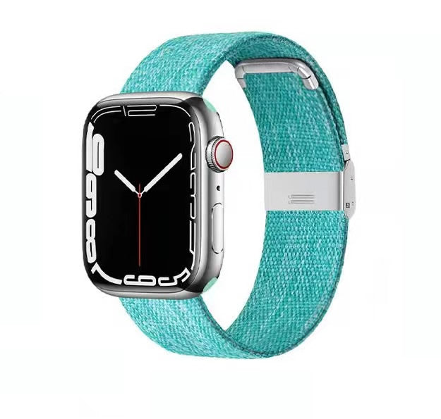 Silver smartwatch with turquoise canvas band and magnetic clasp closure