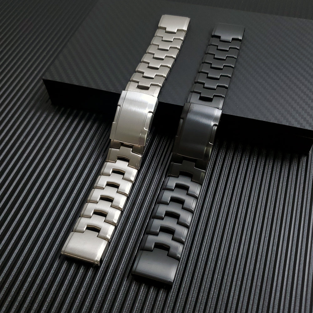 Two QuickFit titanium watch bracelets in silver and gunmetal finishes with segmented links and quick-release clasp system displayed on dark background